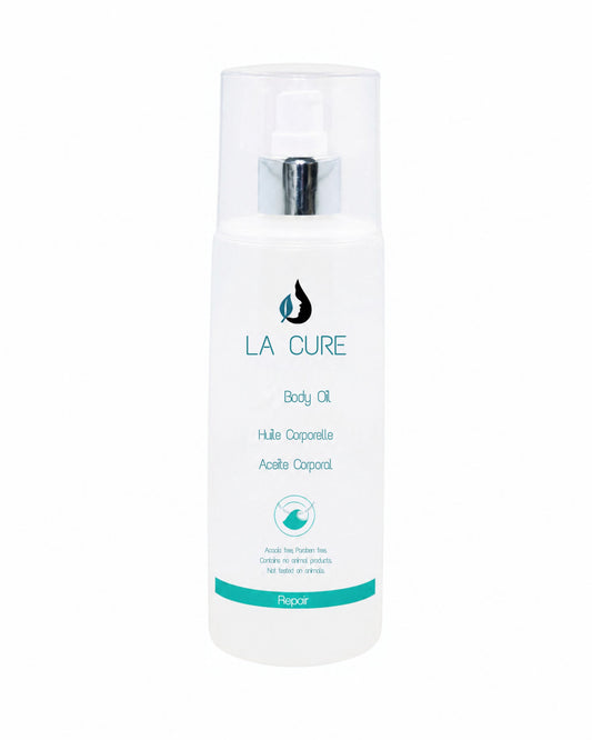 A white bottle of LA CURE Body Oil with a clear cap and silver pump, featuring teal and black text on a white background.