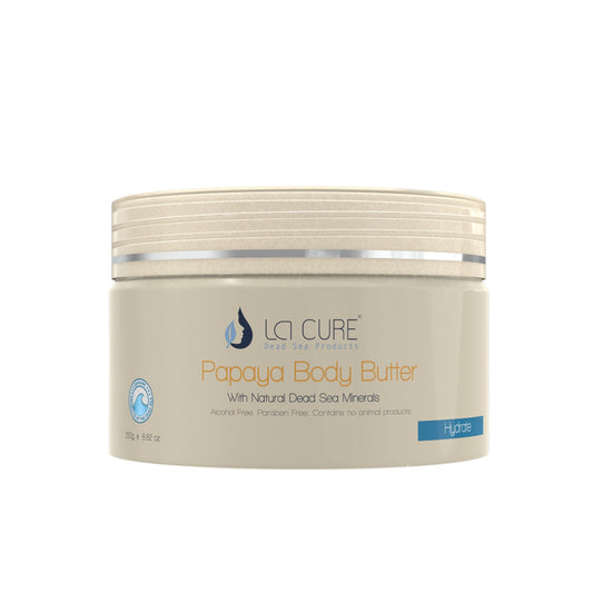 A jar of La Cure Dead Sea Body Butter, specifically the Papaya variant, shown on a plain white background. The container is a light beige/cream color with a matching ribbed lid, featuring orange and blue text on the label.